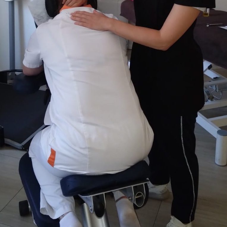 Pressions sur le haut du dos pendant une séance de massage AMMA assis