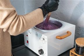 Un chauffe-cire en train d'être remué à la spatule