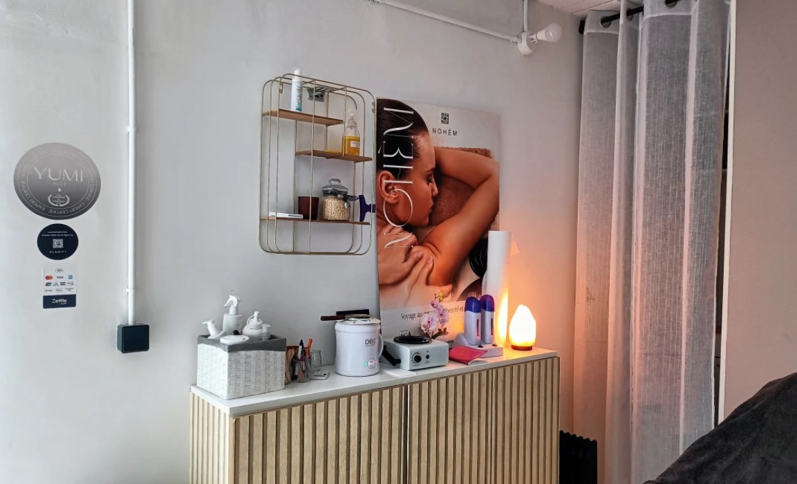 Le plan de travail de l'institut : étagère dorée, appareils de soin, lampe de sel et affiche murale